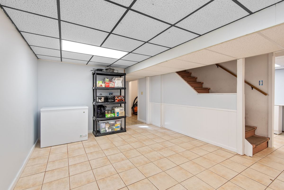 Basement Ceramic Tile Floor with Staircase and Storage Shelving